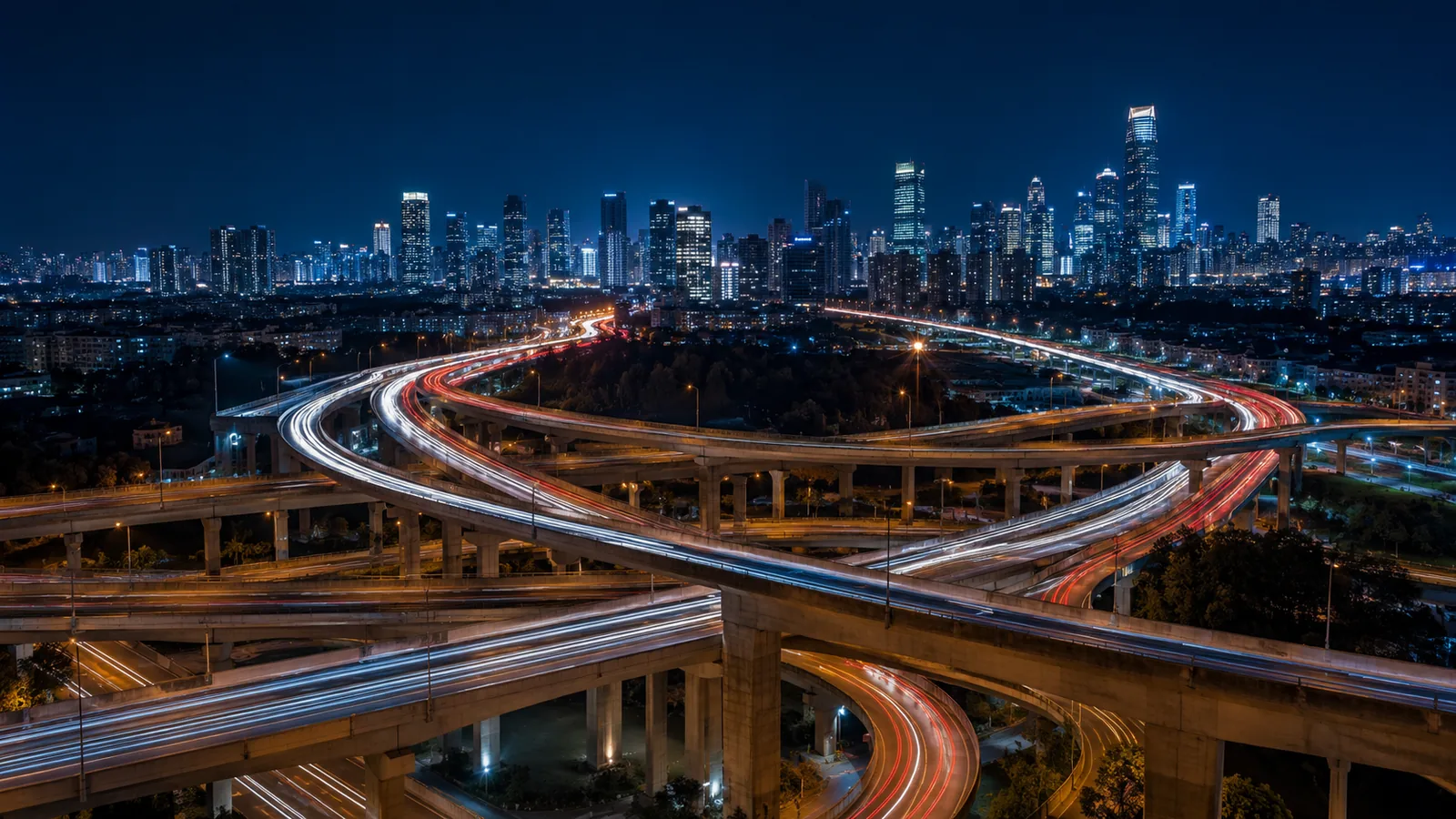 Vista nocturna de un intercambio vial con estelas de luz del tráfico, imagen que ilustra los flujos continuos de la globalización.
