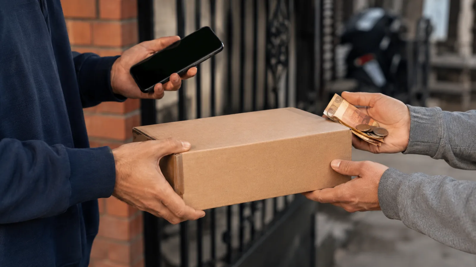Entrega de un paquete de compra en línea en la puerta de una vivienda de un barrio colombiano con pago contra entrega